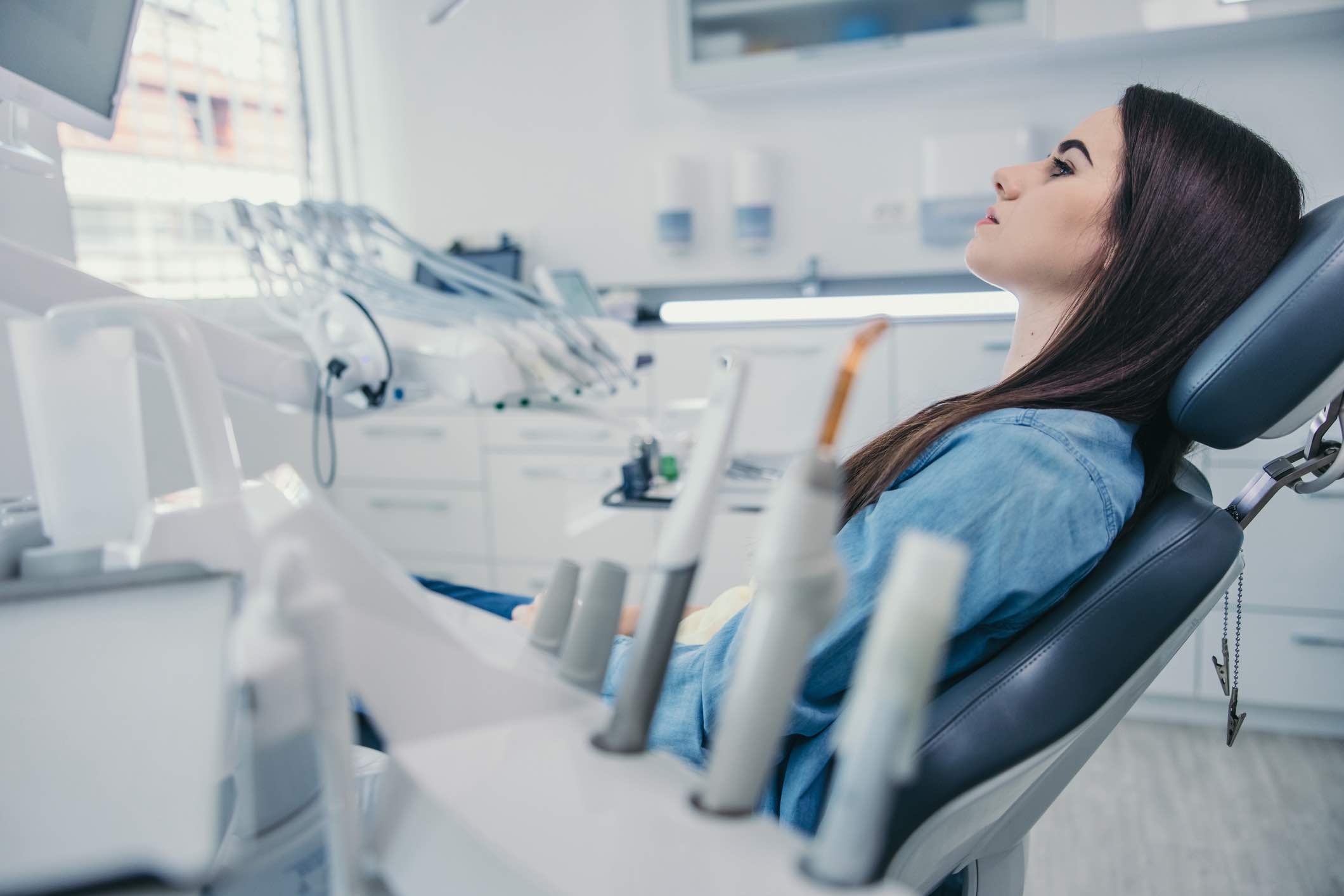 Young woman sitting on dentist chair at dental clinic